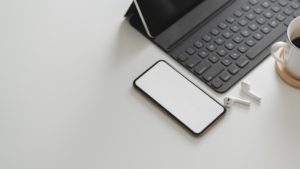white smartphone near black keyboard