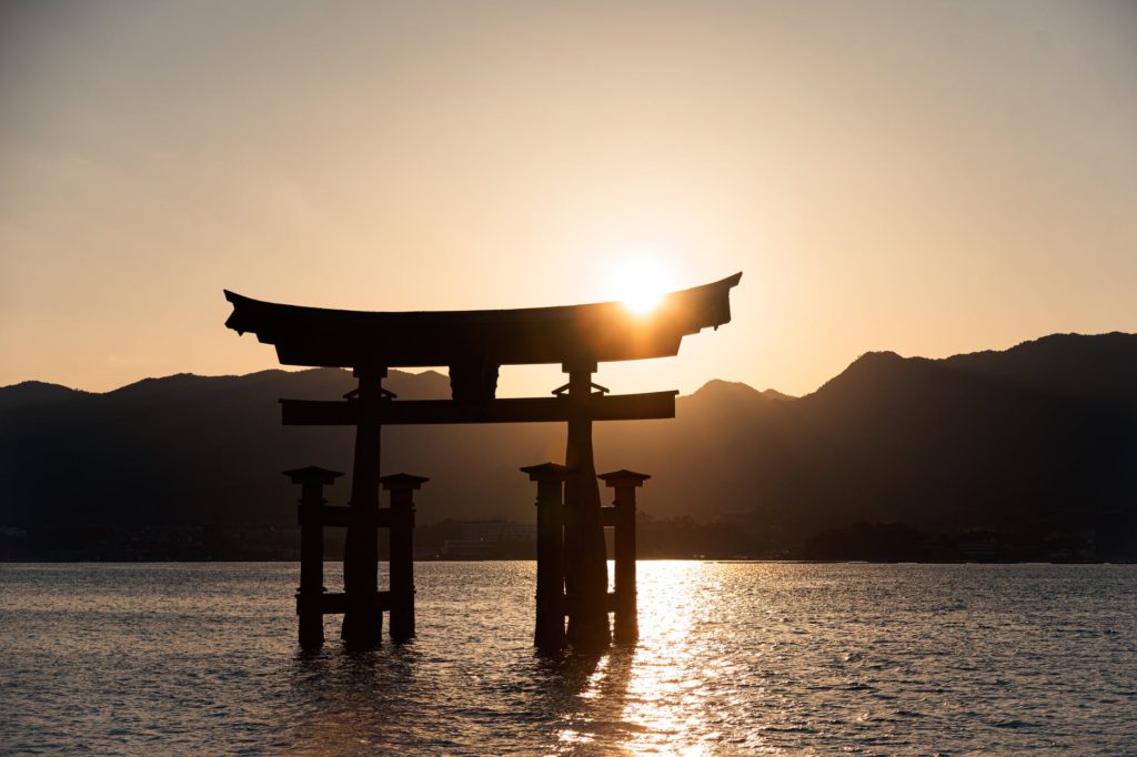 silhouette of a person standing on a wooden dock during sunset