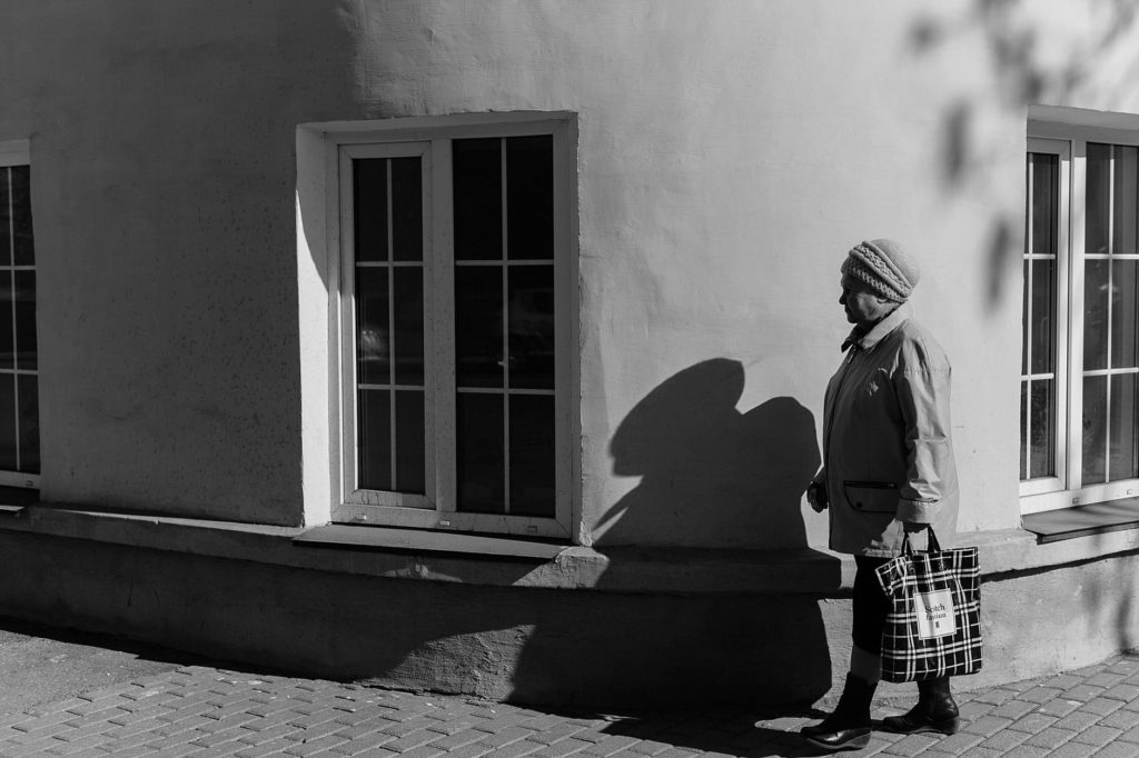 faceless senior woman walking on street